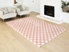 Pink checkered rug on a wooden floor in a living room setting.